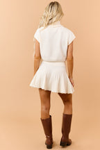 Conjunto de Top Cuello Alto y Falda Plisada en Crema